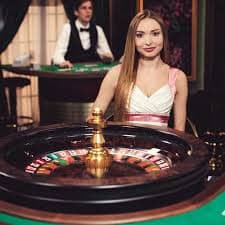 Studio live dealer dengan multiple kamera menampilkan meja baccarat dan roulette
